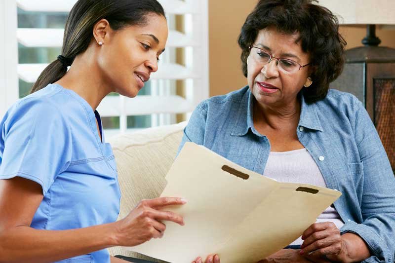 nurse looking at folder with patient
