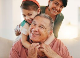 man and granddaughter painting on a canvas